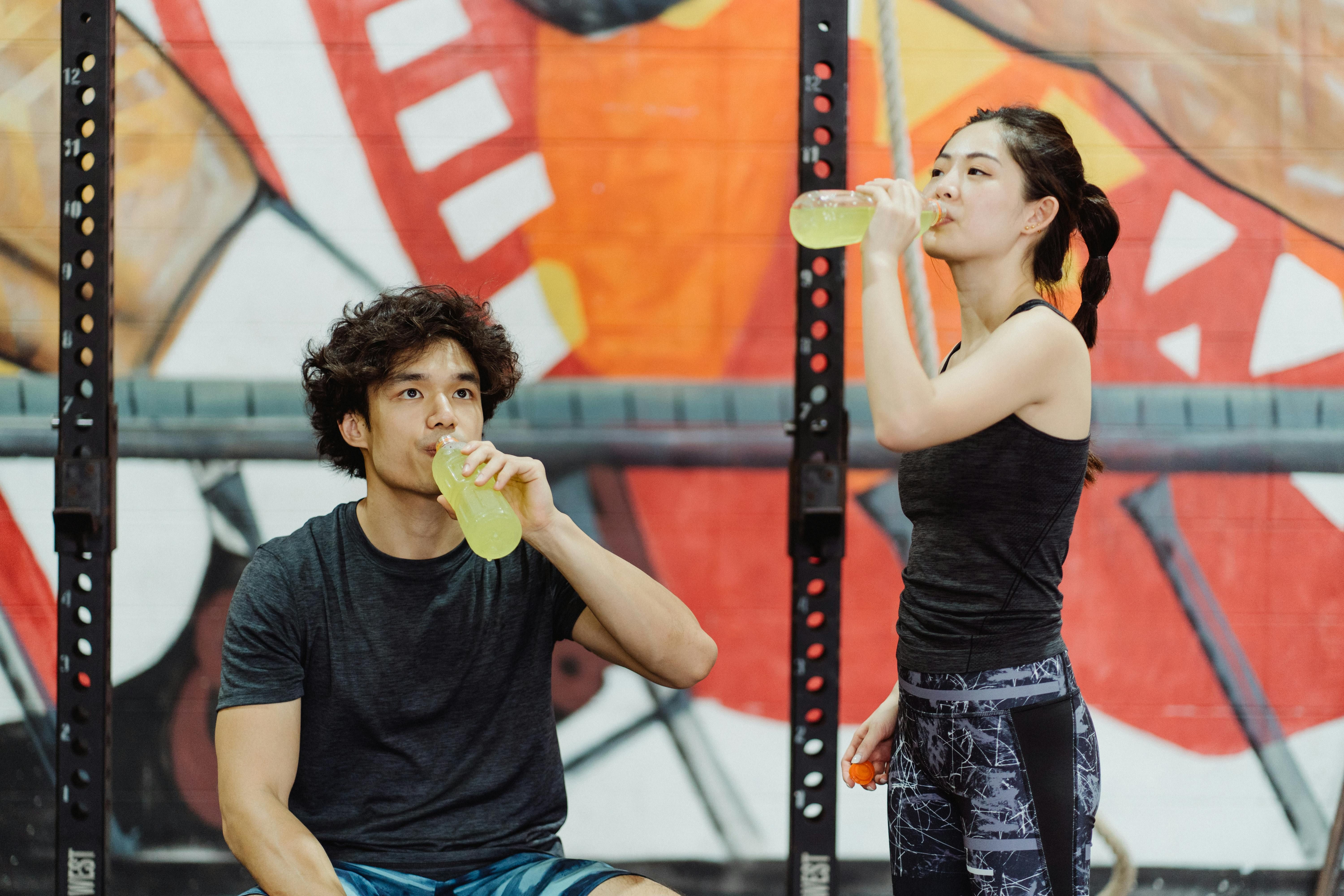 Active Couple Drinking Electrolyte Drinks: Supporting Hydration and Muscle Recovery Naturally An active couple enjoying electrolyte drinks after a workout, helping to replenish hydration and boost recovery naturally.