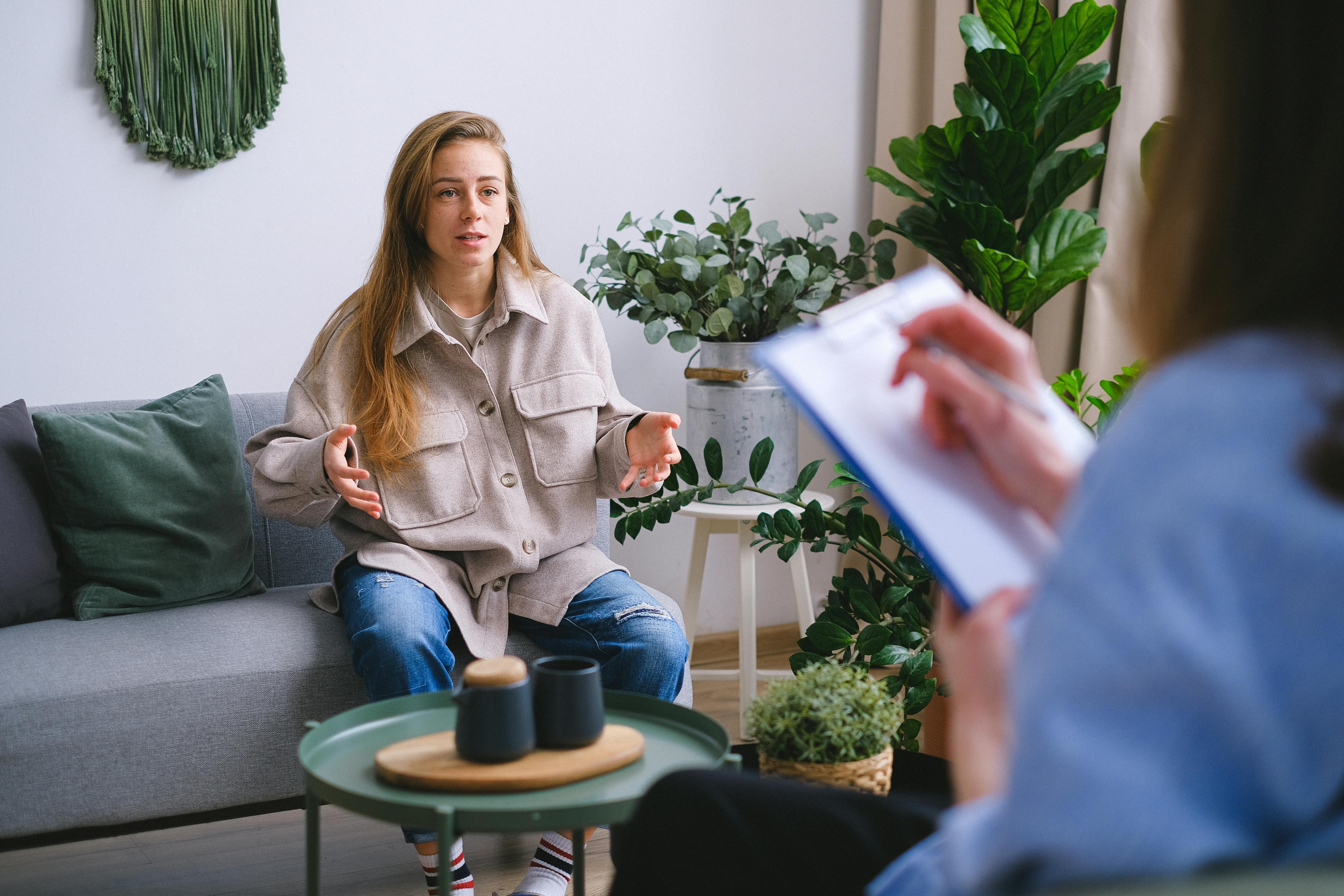Woman in a CBT Therapy Session for PTSD: Healing Trauma and Building Emotional Resilience Through Cognitive Behavioral Therapy A woman attending a CBT session for PTSD, working with a therapist to process trauma and develop coping strategies.