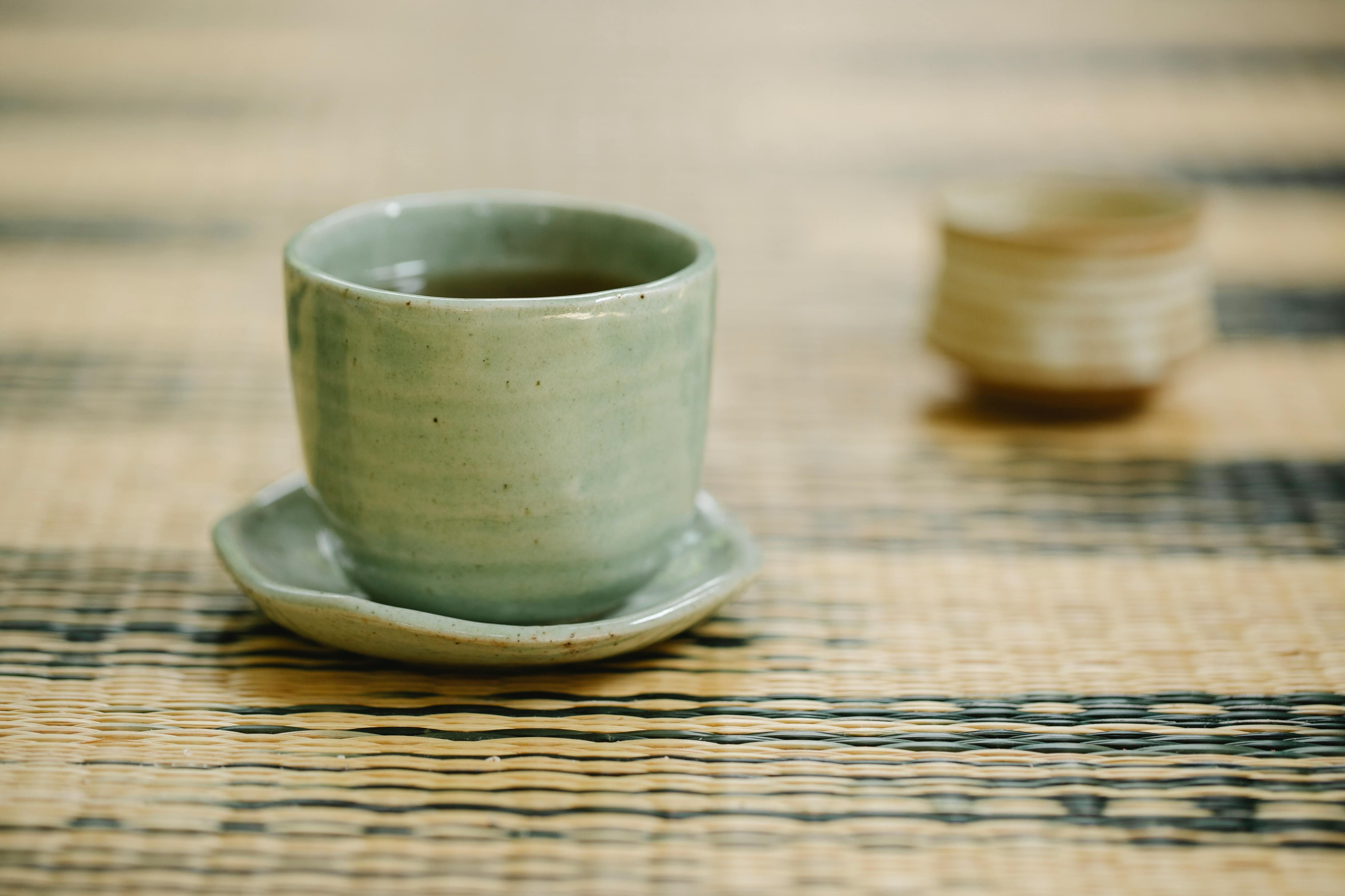 Savoring Black Tea During an Intermittent Fast A elegant ceramic teacup filled with fresh, rich black tea sitting on a rustic wooden surface - the perfect morning ritual while intermittent fasting
