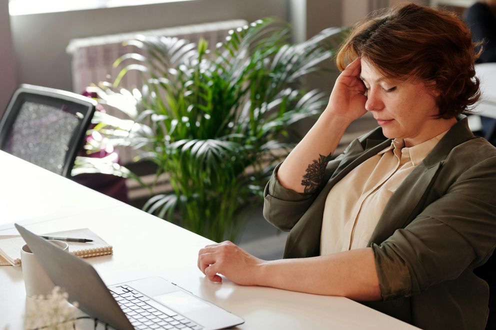 A woman feeling nauseous while intermittent fasting, holding her stomach