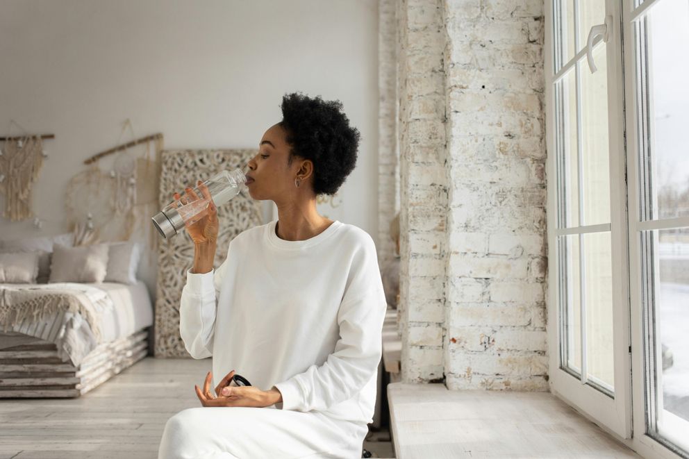 Hydration Boost: Woman staying refreshed with water during intermittent fasting journey Woman staying hydrated with water while practicing intermittent fasting