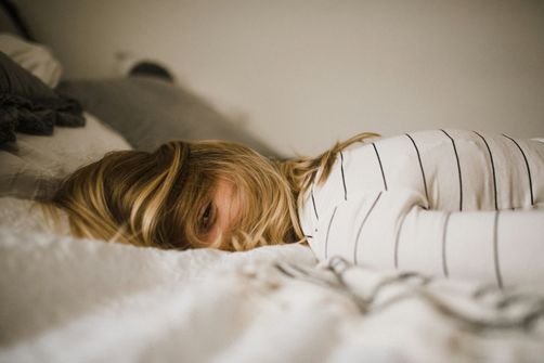The 2024 Guide to Balancing Gut Health and Sleep: How Women Can Improve Both A woman adjusting her sleep routine to improve gut health and balance hormones.