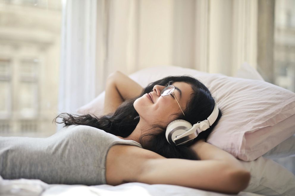 The 2024 Guide to Sound Healing: Sleep Better and Relieve Stress with Binaural Beats and Nature Sounds A woman relaxing before bed, listening to soothing sounds to enhance sleep quality and reduce stress.