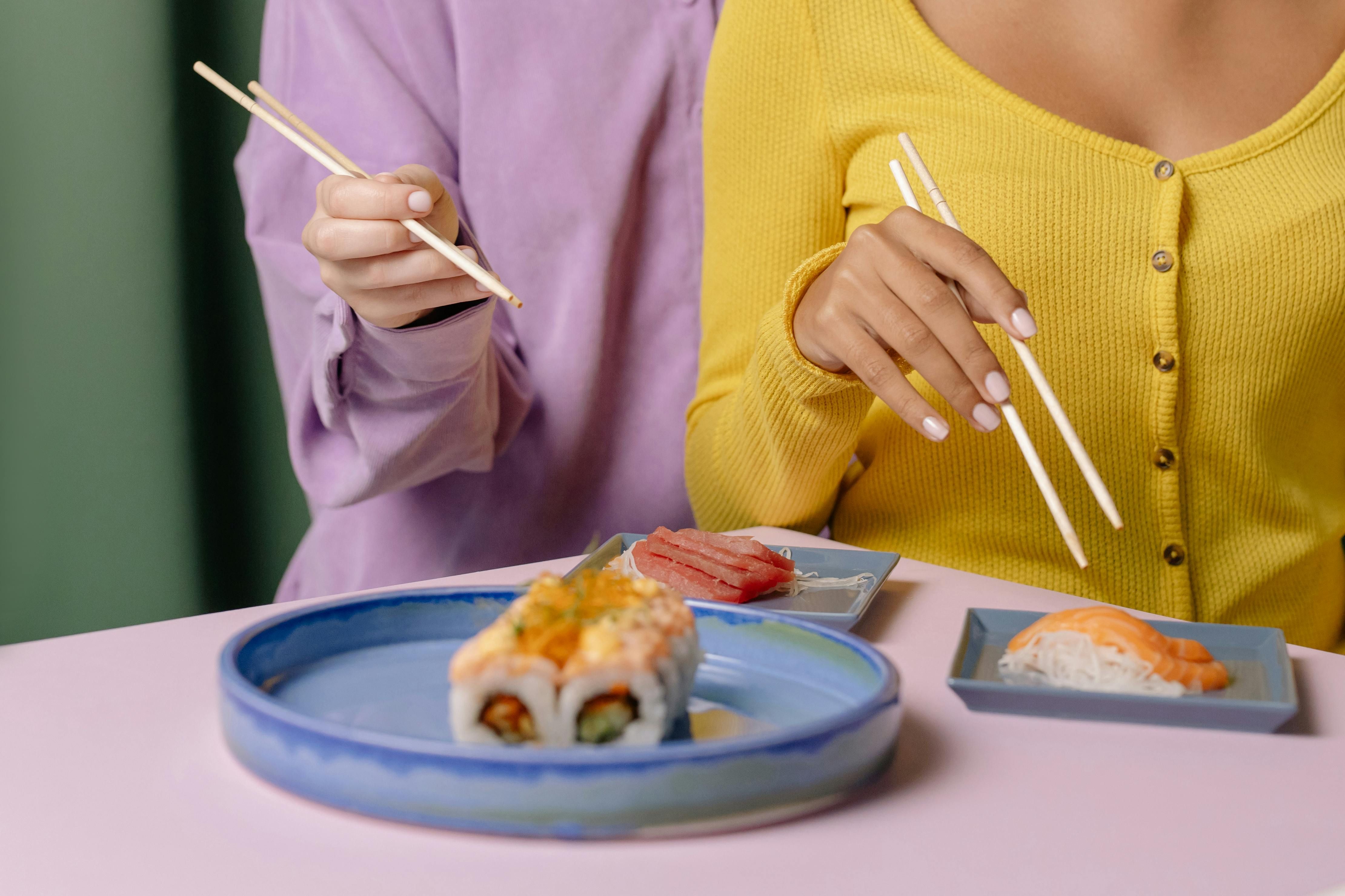 The Delicious Route to Omega-3: Women and Salmon Sushi Woman enjoying salmon sushi, incorporating omega-3 into her diet