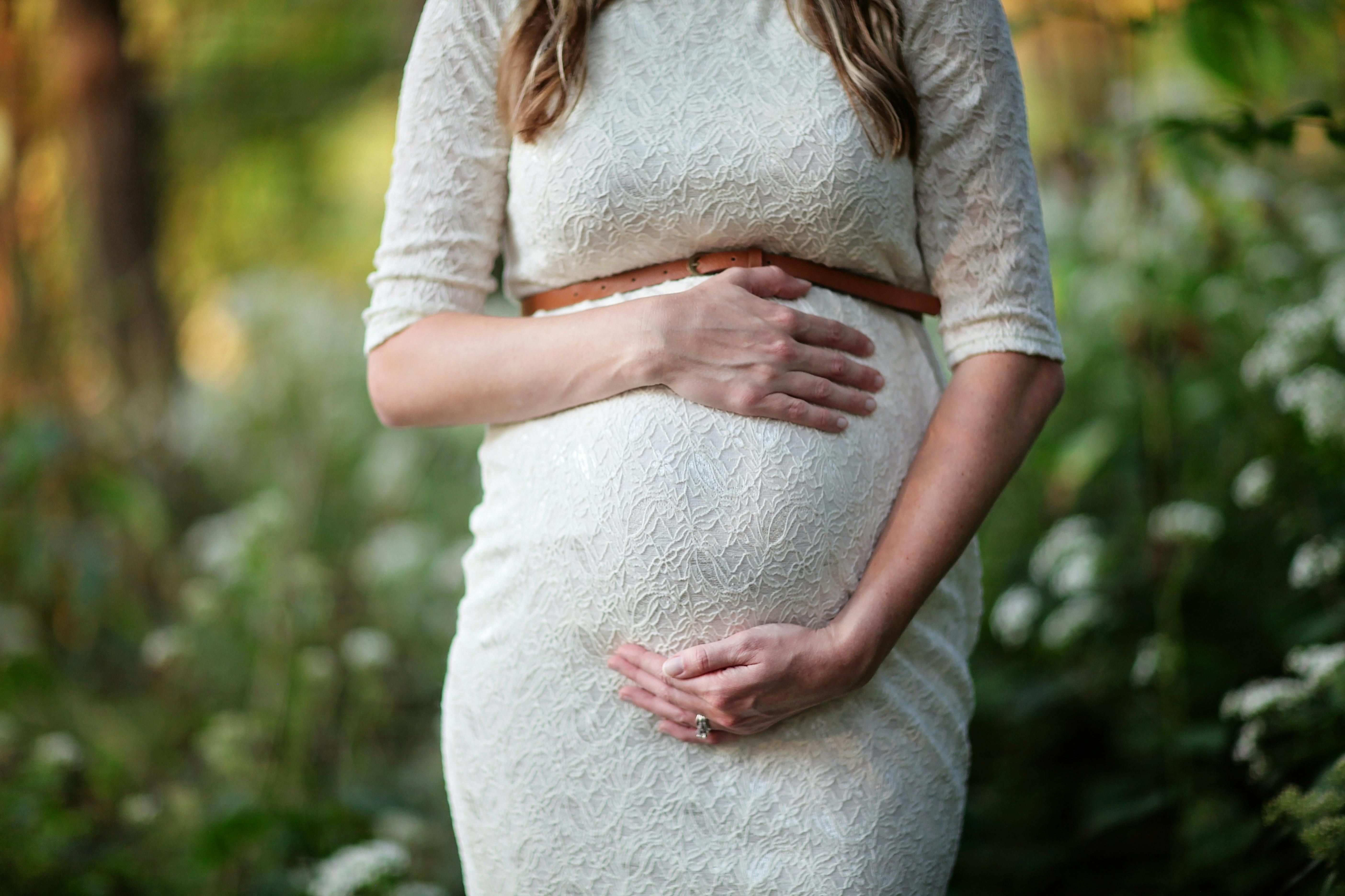 A Woman Embracing Pregnancy: Celebrating Health and Joy During Pregnancy A joyful pregnant woman embracing her pregnancy, radiating happiness and health.