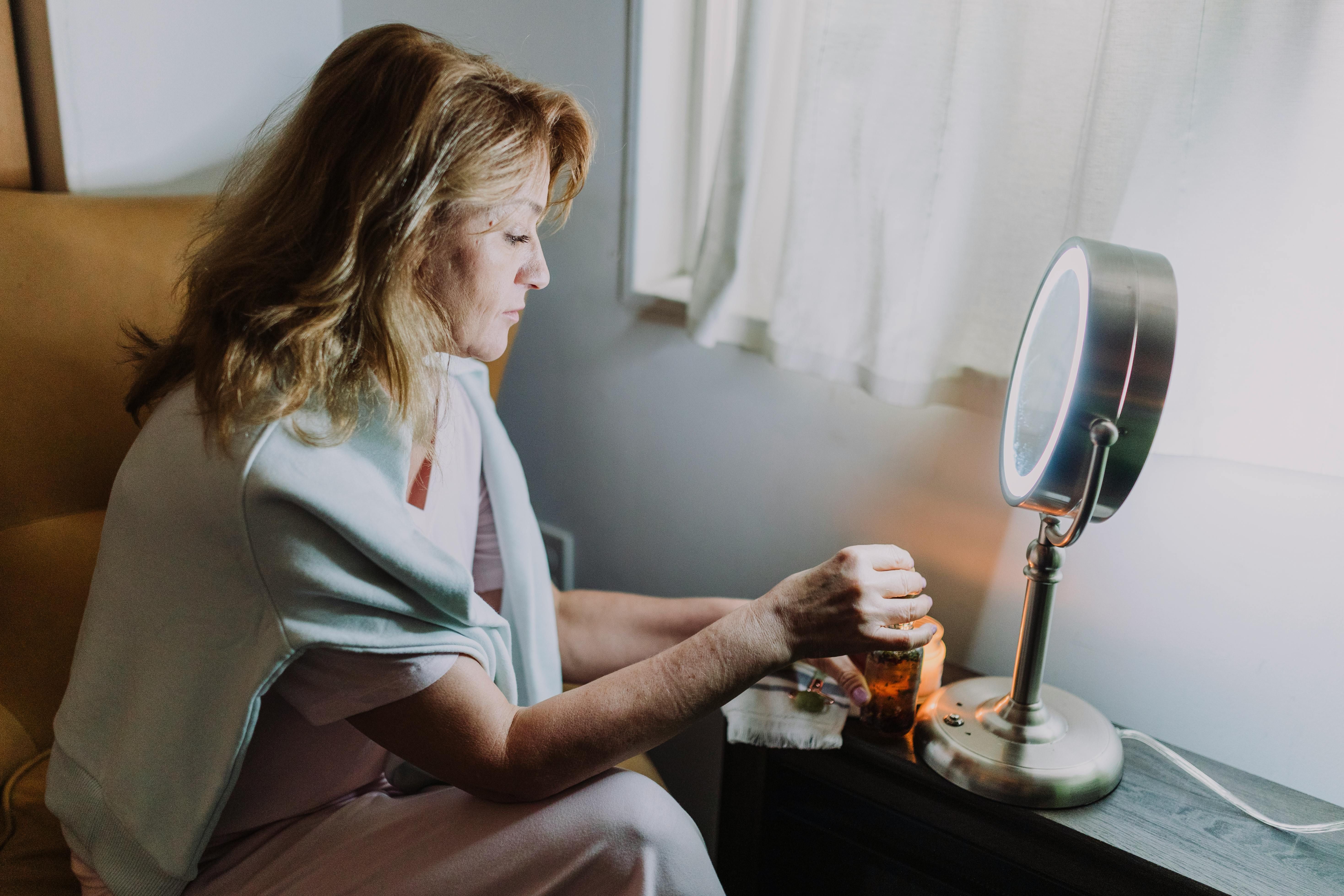 Older Woman Applying Night Serum: Hydrating and Rejuvenating Skin for Anti-Aging Benefits An older woman applying a serum as part of her nighttime beauty routine to hydrate and rejuvenate her skin for a youthful glow.